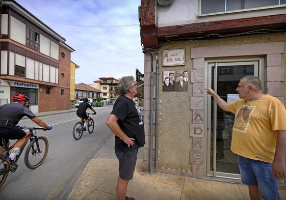 Dos vecinos de La Pesa observan una de las fotografías en la calle del Sol.