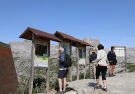 Turistas consultan la información sobre las rutas en el teleférico.