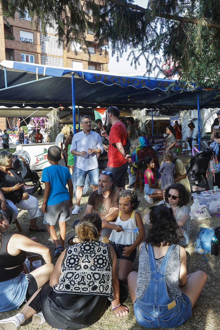 Gente de todas las edades se sienta en el parque a disfrutar de su refresco.