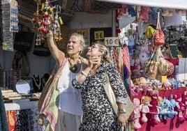 Dos mujeres observan uno de los puestos de artesanía del Festival de las Naciones de Santander