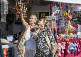 Dos mujeres, este fin de semana, observan los productos de uno de los puestos de artesanía repartidos por el recinto del festival.