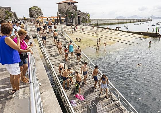 Un grupo de turistas y bañistas en la zona del muelle de Castro Urdiales.