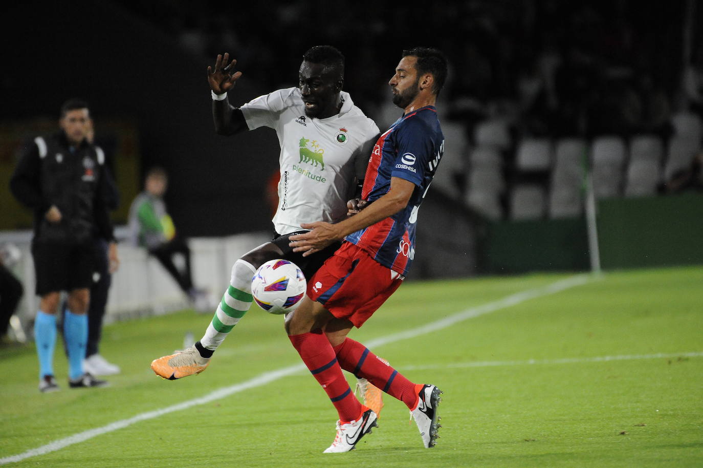 Lago Junior pugna por la pelota con un jugador del Huesca. 