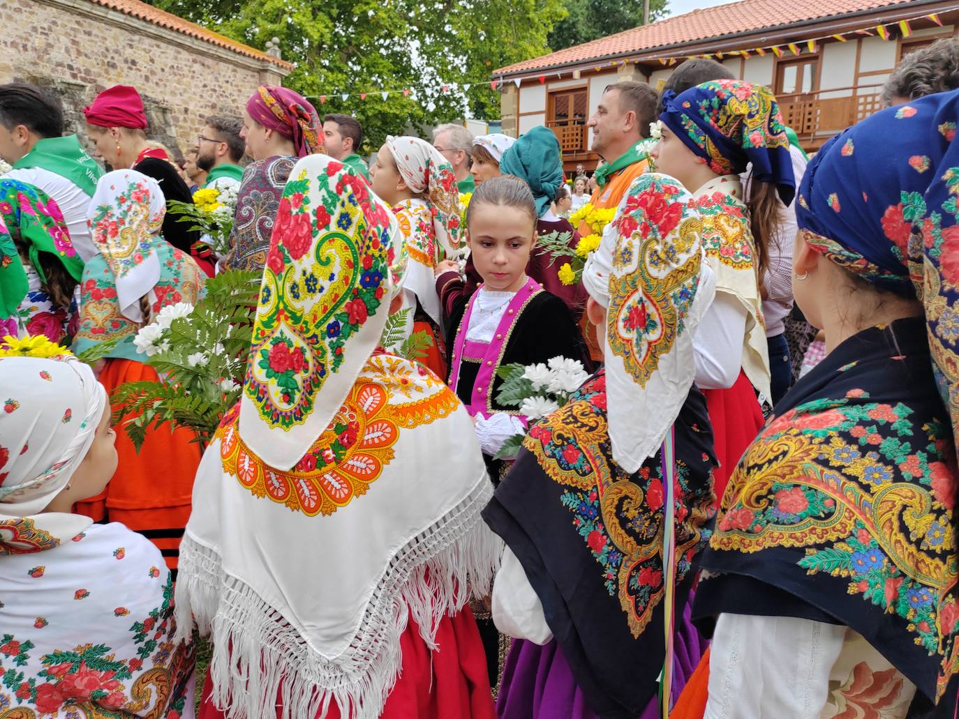 Los grupos de jóvenes esperan a que llegue su turno para dejarle sus flores a la Virgen