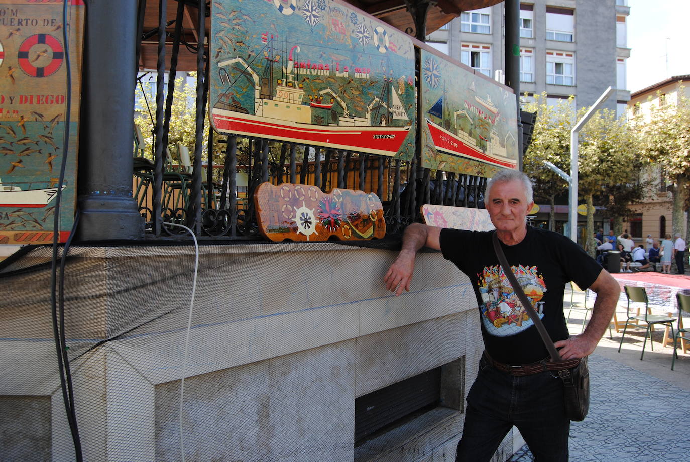 El santoñés Pedro Hernández 'Willy' en la plaza de San Antonio junto a sus cuadros de temática marinera con espectaculares dibujos de embarcaciones  de la villa. Las obras, que gustaron mucho, incluyen el código de la mar y detalles de timones, salvavidas, especies marinas o el escudo de Santoña. 