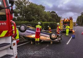 Los bomberos aseguran el vehículo accidentado en la A-8, a la altura de Laredo.