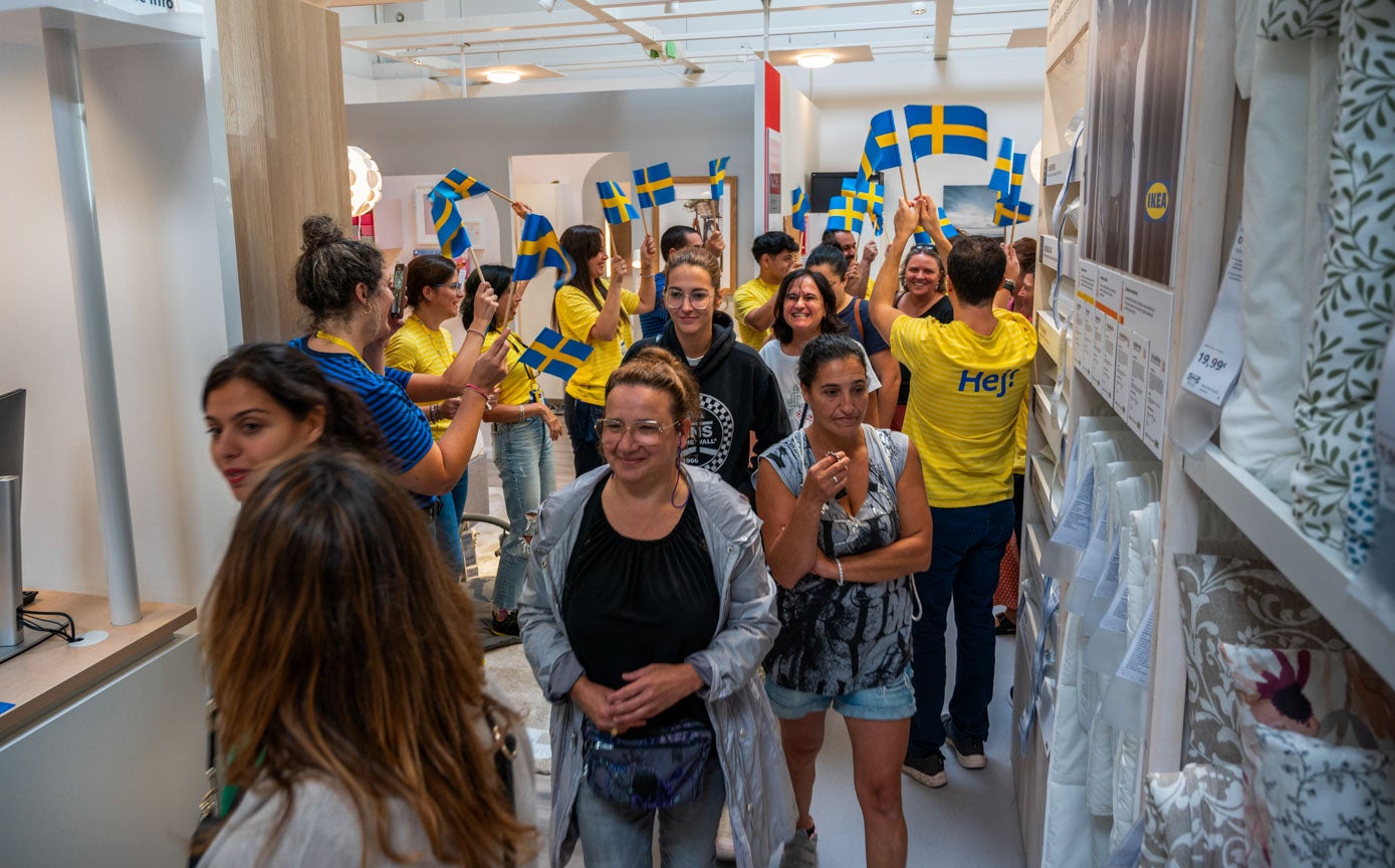 Los primeros clientes, recibidos por los empleados con banderas de Suecia.