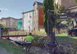 Una máquina pesada sobre el terreno donde se están produciendo los soplados trabaja para encauzar el arroyo.