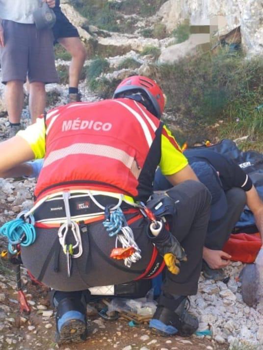 El médico, atiende a hombre antes de subirlo al helicóptero.