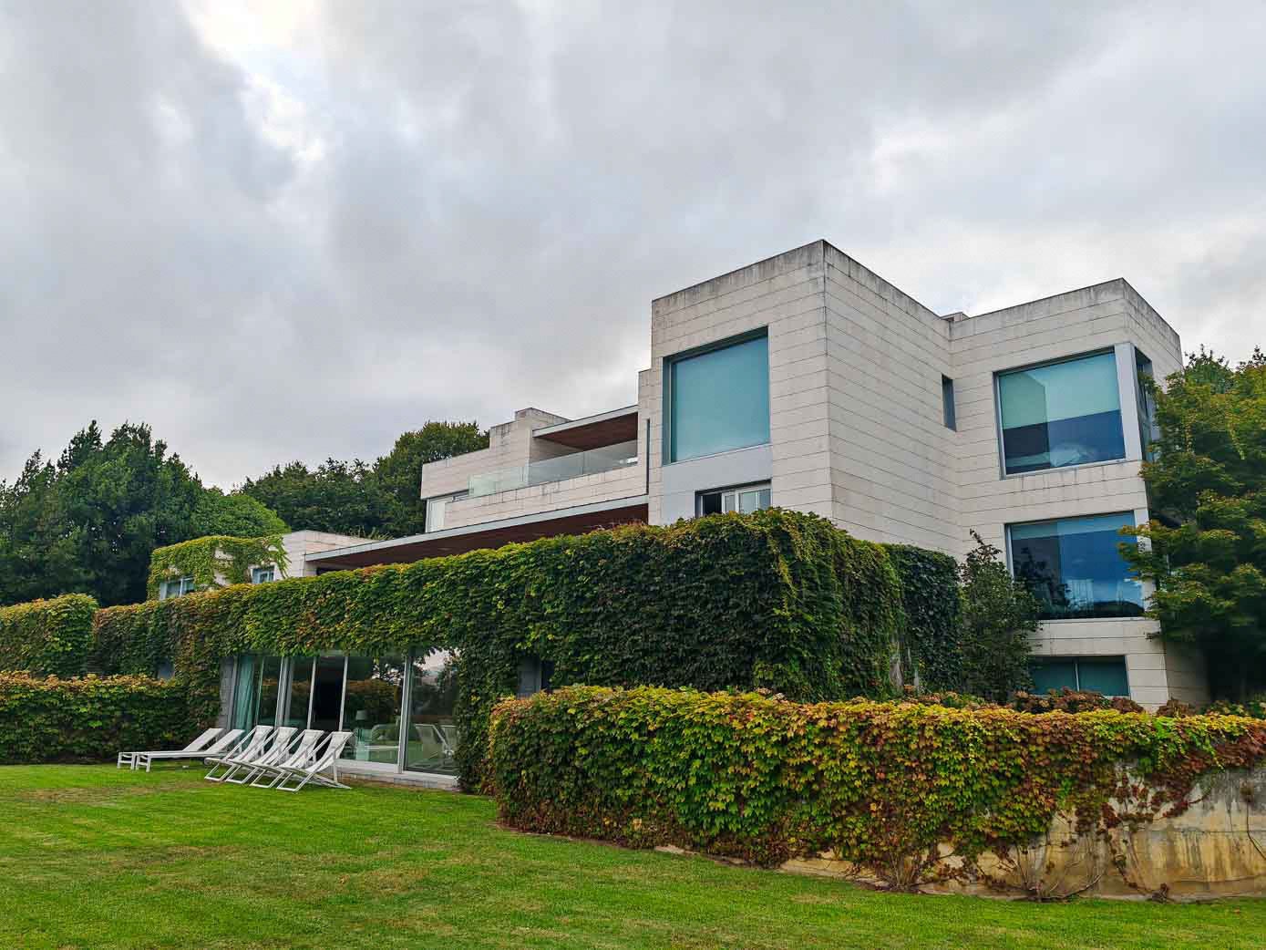 La casa, vista desde el jardín, con la terraza sobre el cuerpo cubierto por la enredadera.