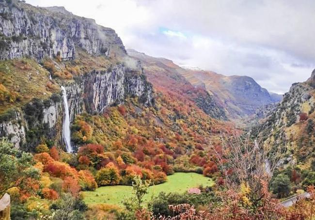 La cascada, a la izquierda, en un marco de colores propios de la estación.