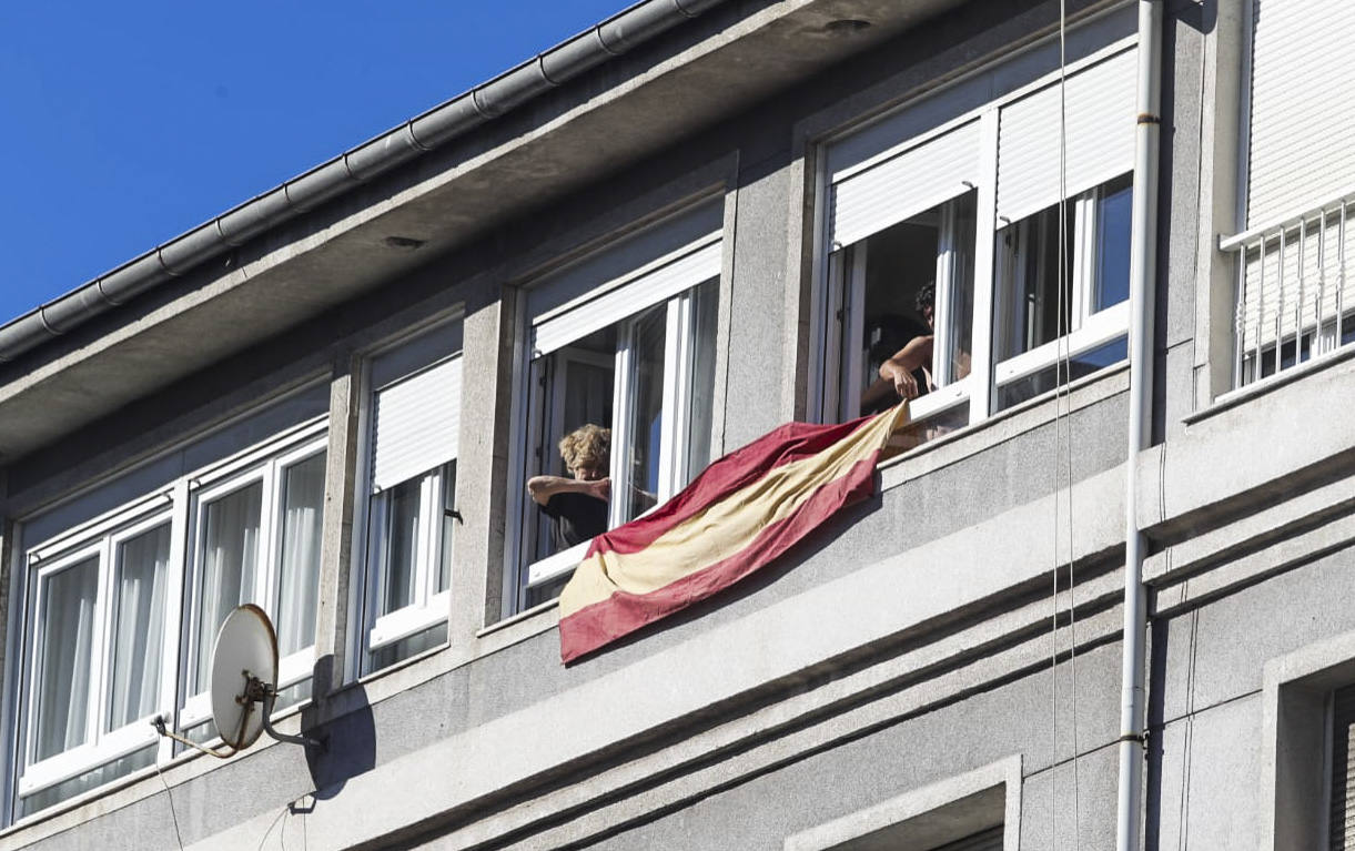 Vecinos de la calle Sevilla, en Santander, desplegando la bandera de España en la fachada de su edificio para recibir al Rey,