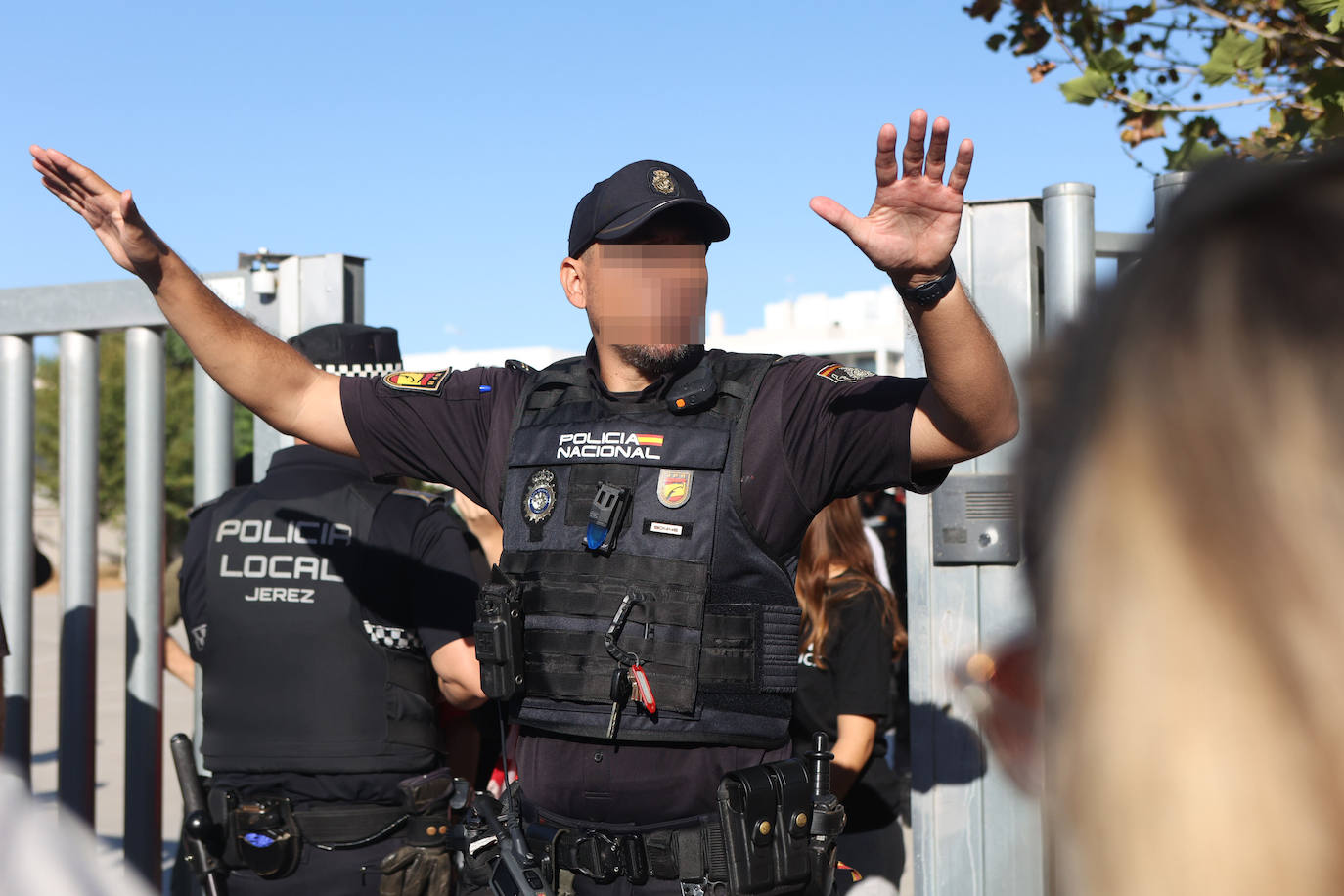 Un agente intenta mantener la calma entre los familiares de los chavales.