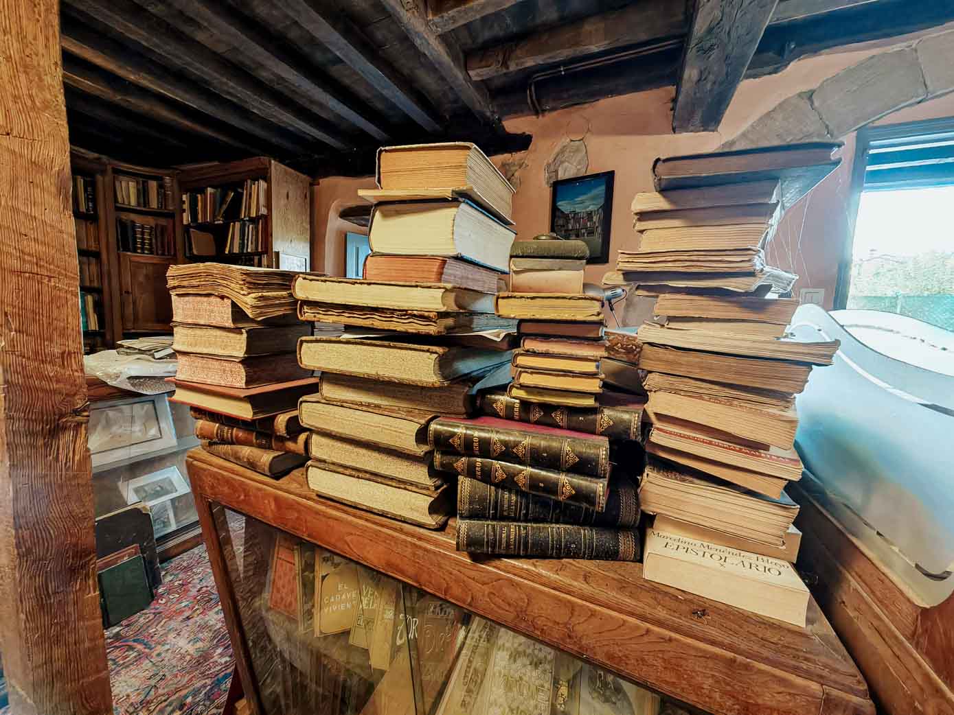 Los libros se apilan por todos los rincones de la casa de Carmichael, no solo en las librerías, como en esta mesa de madera.