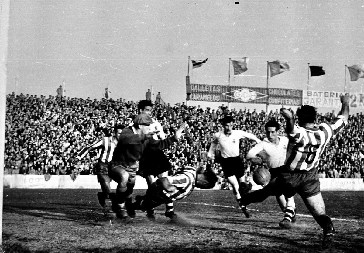 Un jovencísimo Paco Gento dispara con la zurda ante la oposición de la defensa sportinguista.