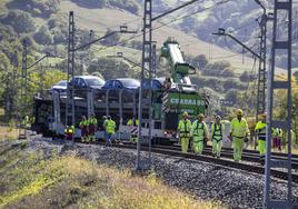 Los operarios, en los trabajos para encarrilar en las vías los vagones accidentados el pasado lunes en Lantueno.
