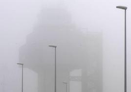 Detalle de la torre de control del Seve Ballesteros cubierta por una densa niebla.