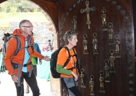 Dos peregrinos entran por la Puerta del Perdón del monasterio de Santo Toribio