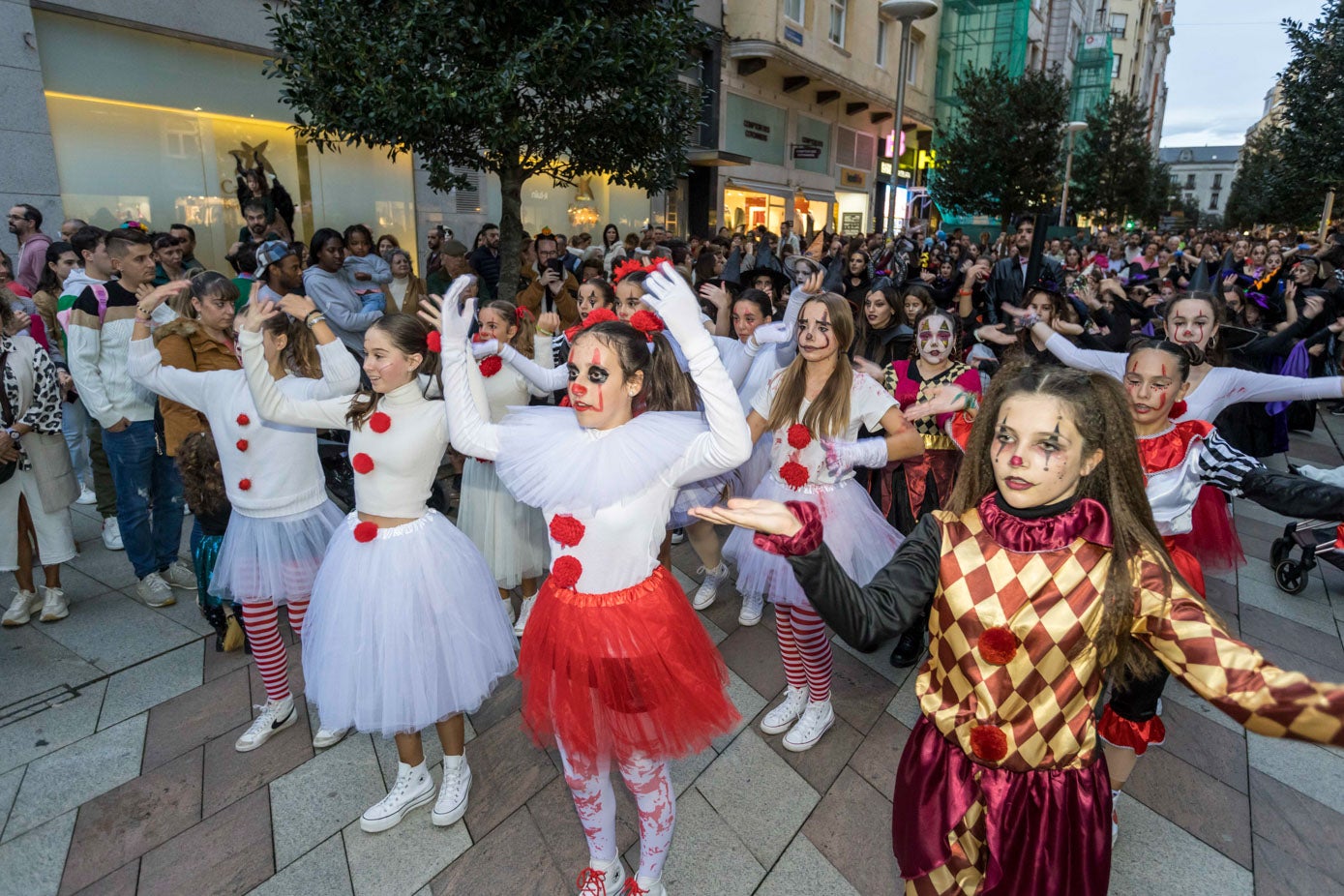 Varias participantes del pasacalles, vestidas de payasos y arlequines.