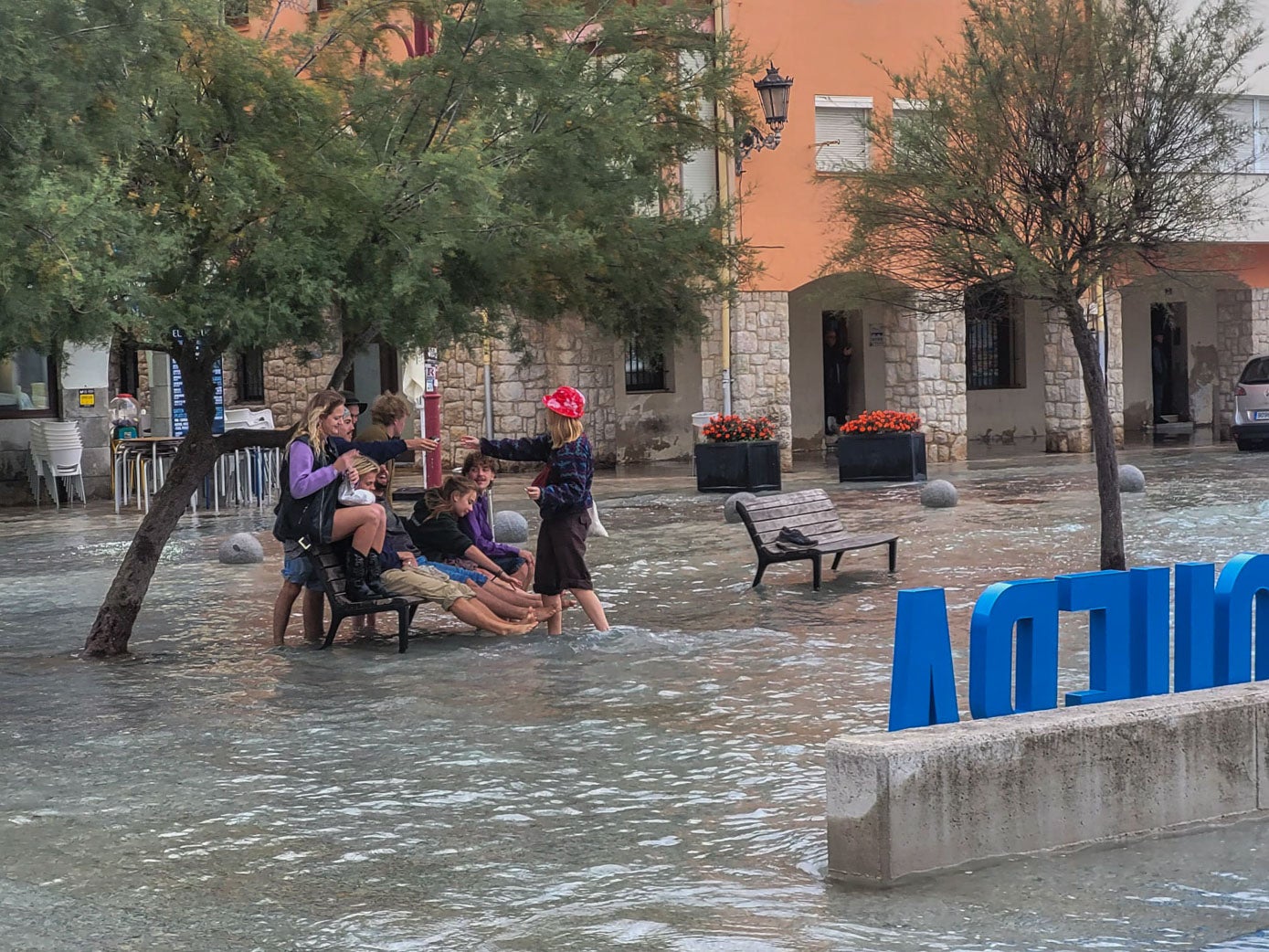 Un grupo de extranjeros fotografiándose en un banco rodeados por el mar