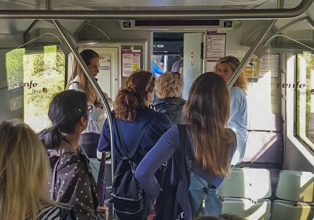 Imagen principal - Arriba, pasajeros esperando a ser transbordados. Abajo, la Guardia Civil auxilió las labores de los operarios de Renfe, en traspaso de un tren a otro.