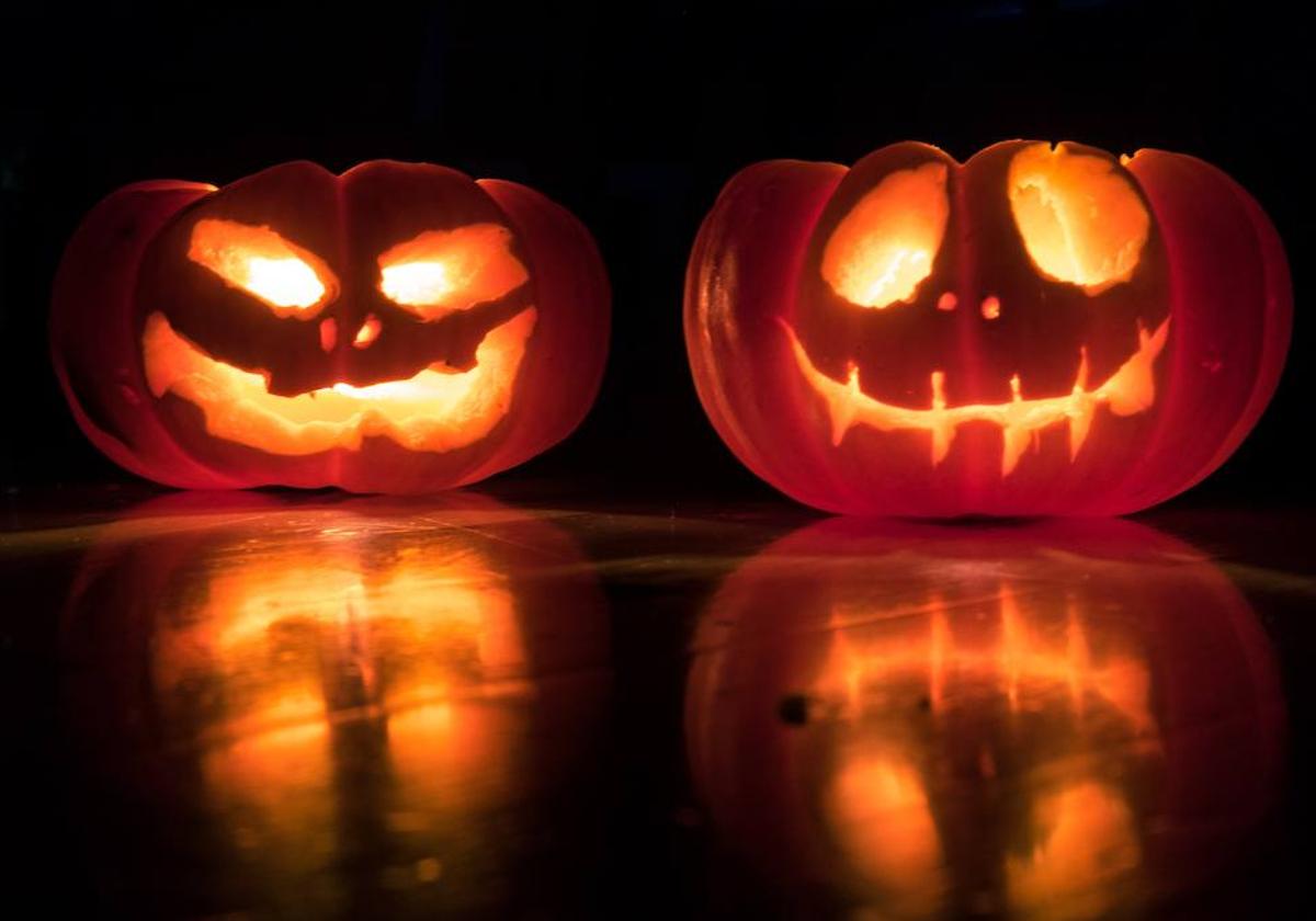 Dos calabazas naturaleza vaciadas y con una vela dentro.