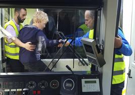 Dos operarios de Renfe ayudan a una mujer a pasar de un convoy a otro.