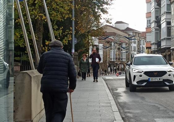 Ciudadanos paseando por una calle principal y comercial de Reinosa, en la avenida del Puente Carlos III.