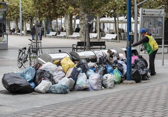 Un vecino intenta hacer uso de un contenedor soterrado esquivando toda la basura que le rodea