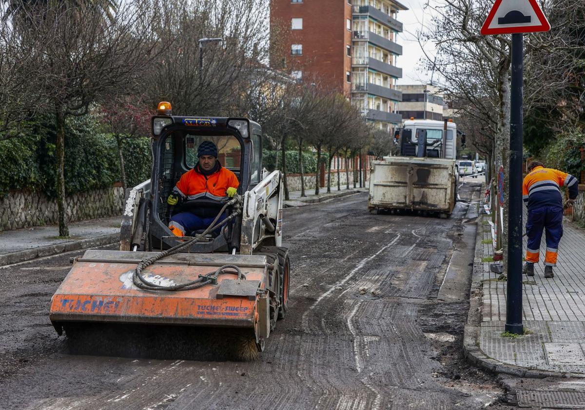 Operarios y máquinas trabajando en el asfaltadode una calle en Torrelavega.