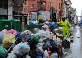 Un operario retira bolsas de basura esta mañana en una céntrica calle de Santoña.