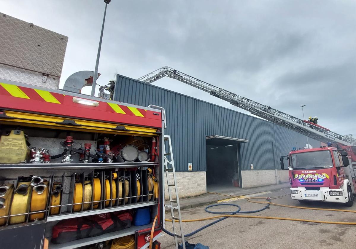 El fuego sale por la chimenea en el incendio de un taller en Colindres