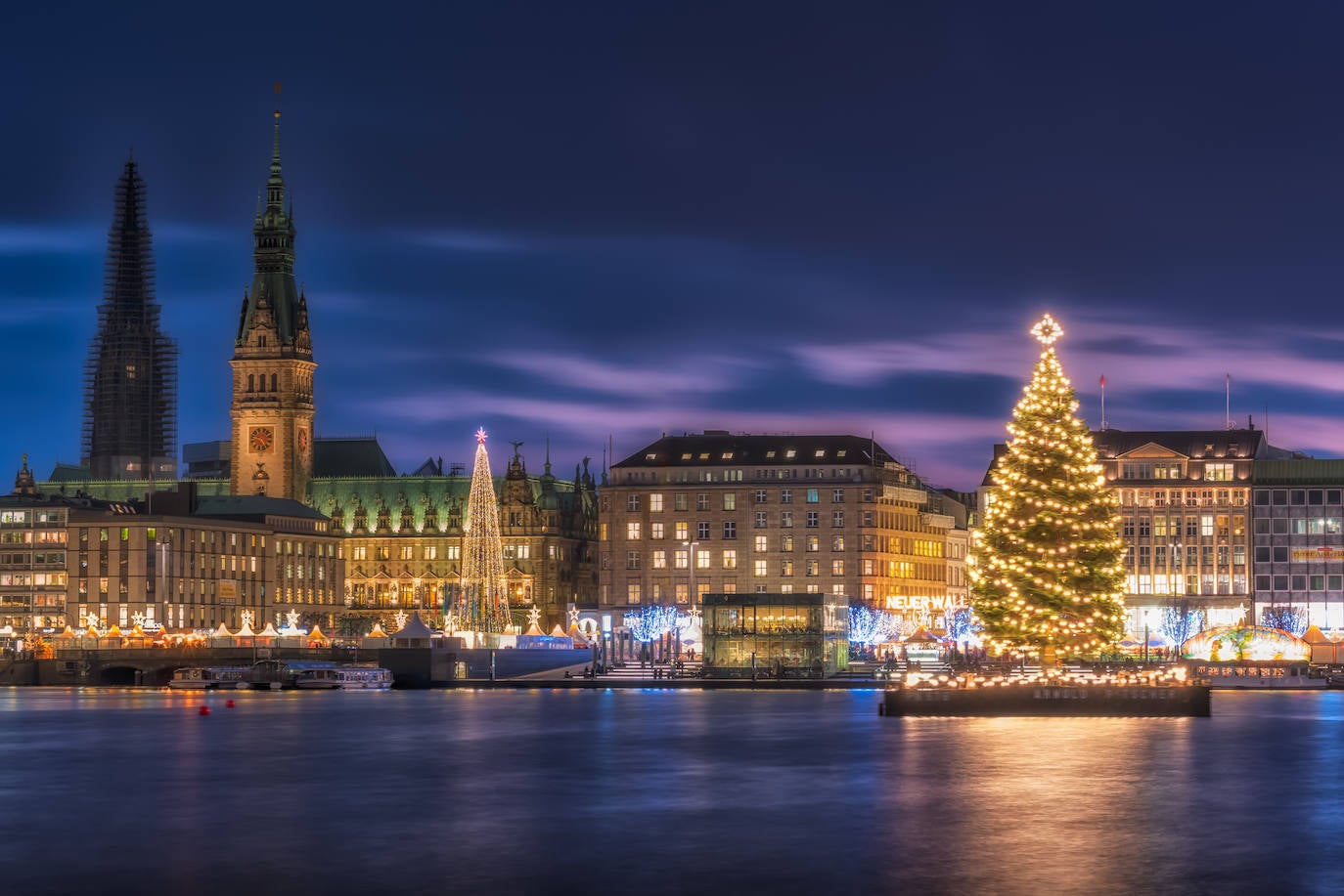 Hamburgo, al igual que Berlín, se transforma en un lugar verdaderamente mágico durante la temporada navideña. ¿La razón? La ciudad alberga varios mercados navideños distribuidos en lugares emblemáticos, todos ellos adornados con bonitos árboles que añaden un toque festivo inconfundible. ¿Y cuál destaca como el más especial? El que flota sobre las tranquilas aguas del lago Alster.