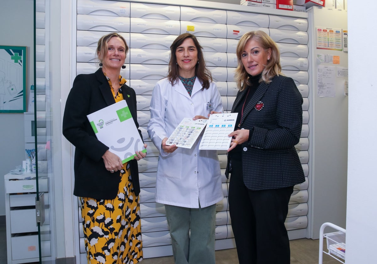 La alcaldesa de Polanco, Rosa Díaz, junto a la decana del Colegio de Farmacéuticos de Cantabria, Rita de la Plaza Zubizarreta, y la responsable de una de las farmacias del municipio muestran el pastillero gigante.