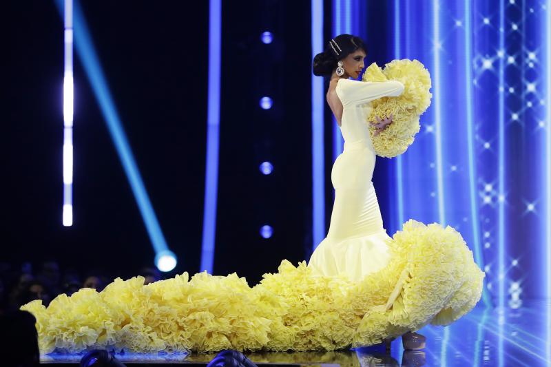 La española Athenea Pérez se coló entre las diez mujeres más guapas del mundo. En la imagen desfilando con un traje de flamenca de color amarillo diseñado por la marca Siempreviva de Sevilla.