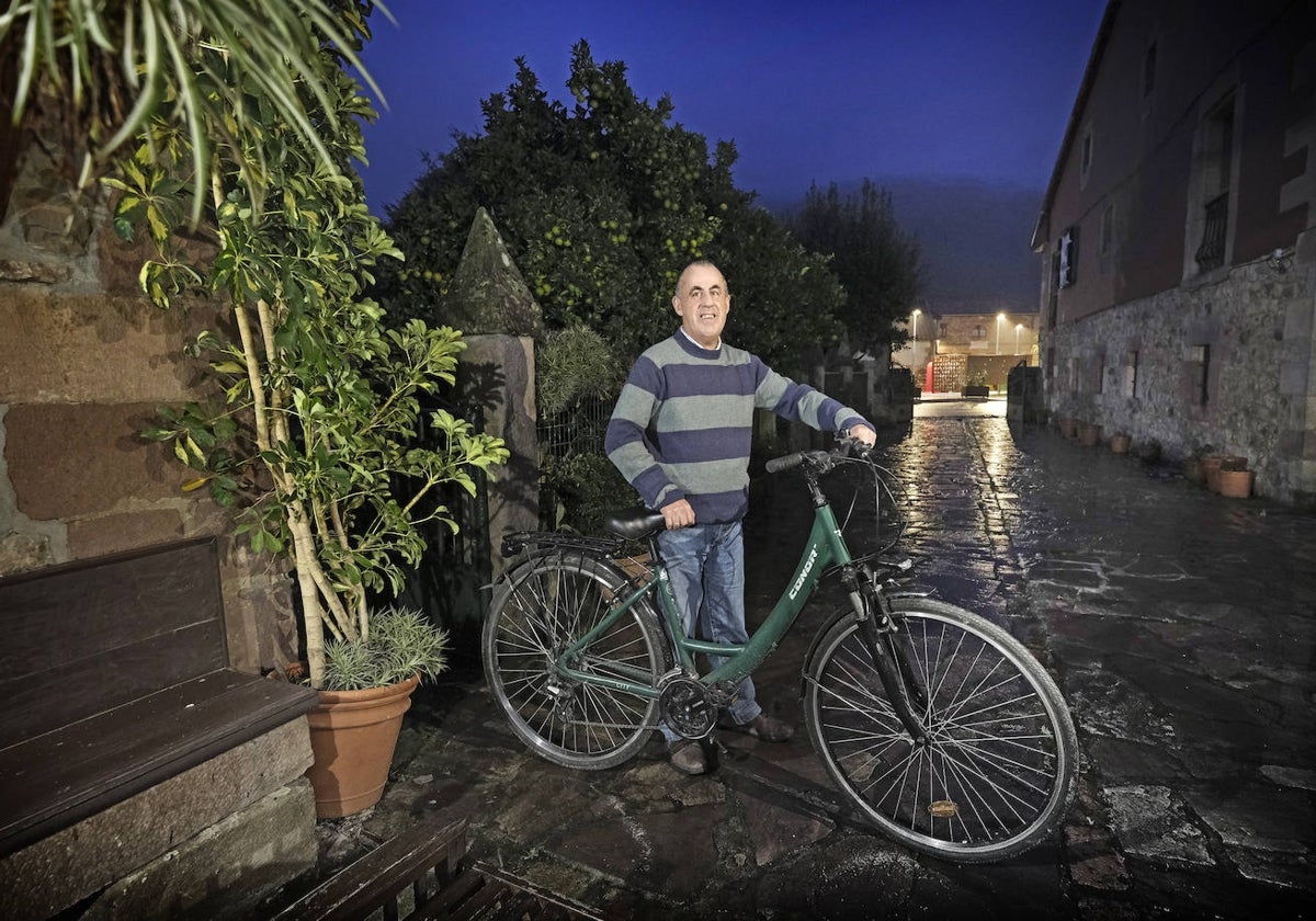 Ignacio posa junto a su bicicleta en la portalada de su casa en Cos, Mazcuerras.