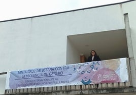 La alcaldesa de Bezana, Carmen Pérez, en el balcón del Ayuntamiento junto a la pancarta que condena la violencia de género.