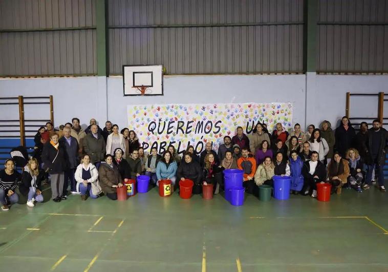 Medio centenar de padres y madres de alumnos del colegio Marqués de Estella, en Peñacastillo, posan junto a la pancarta que reclama un pabellón digno.