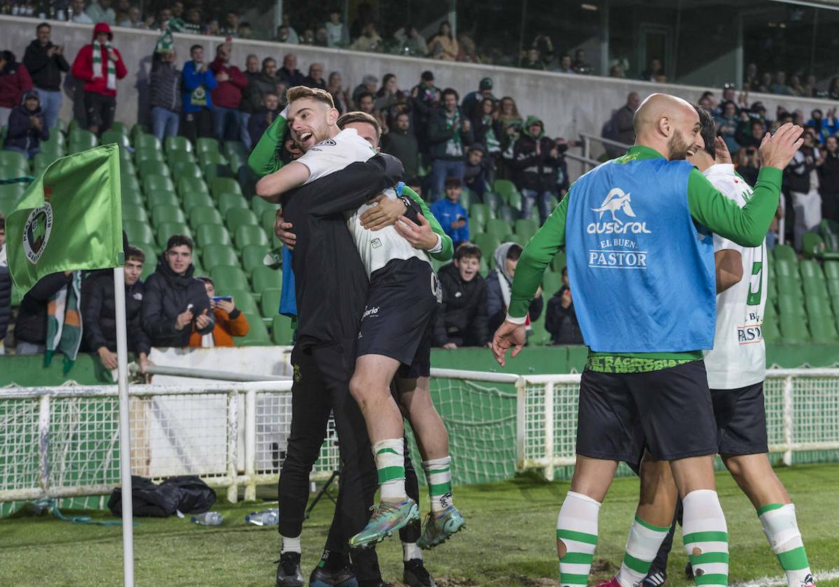 Peque, abrazado por Dani Fernández y el preparador físico, Dani Salvador.