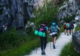 Varias personas, durante una ruta de senderismo por la montaña.