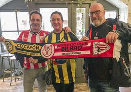 Hinchas del Cayón y el Athletic, con una de las bufandas conmemorativas del partido.