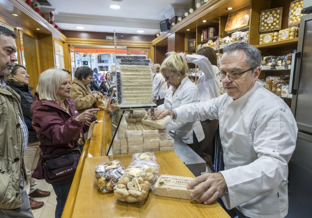 Alfredo Mira, en primer término, en el mostrador de la tienda junto a sus compañeras atendiendo a los clientes.