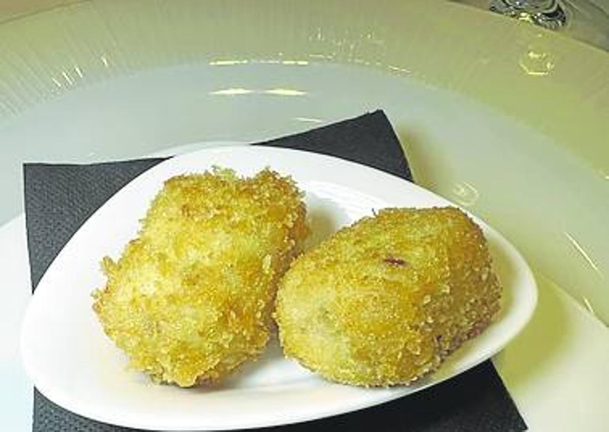 Imagen secundaria 1 - En la fotografía superior, salteado de solomillo de vaca. En la fotografía de la izquierda, croquetas caseras y, a la derecha. ensalada de tomate, cecina y queso.