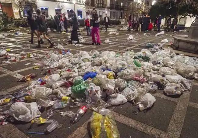 Los jóvenes más noctámbulos apuraron las últimas horas de la Nochevieja, entre bolsas de basura y restos de botellón, en la Plaza de Pombo.