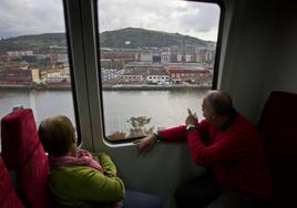 Dos pasajeros de un tren en el trayecto de Santander a Bilbao a su llegada a la capital vizcaína.