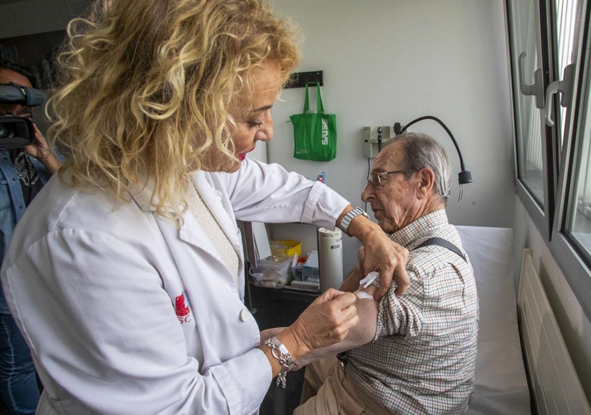 Una enfermera administra una vacuna a un paciente.