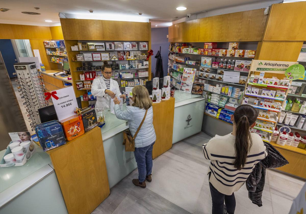 Una profesional atiende una farmacia ubicada en el centro de Santander.