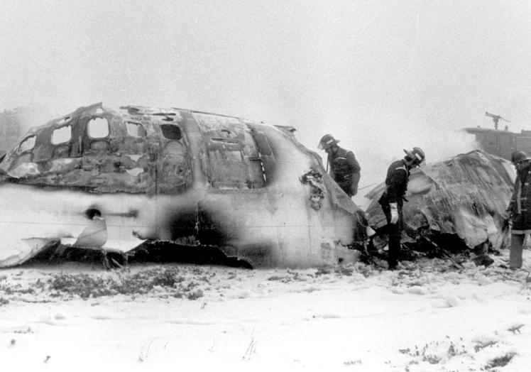 Miembros del Cuerpo de Bomberos inspeccionan los restos calcinados de uno de los aviones implicados en el accidente del 7 de diciembre de 1983.