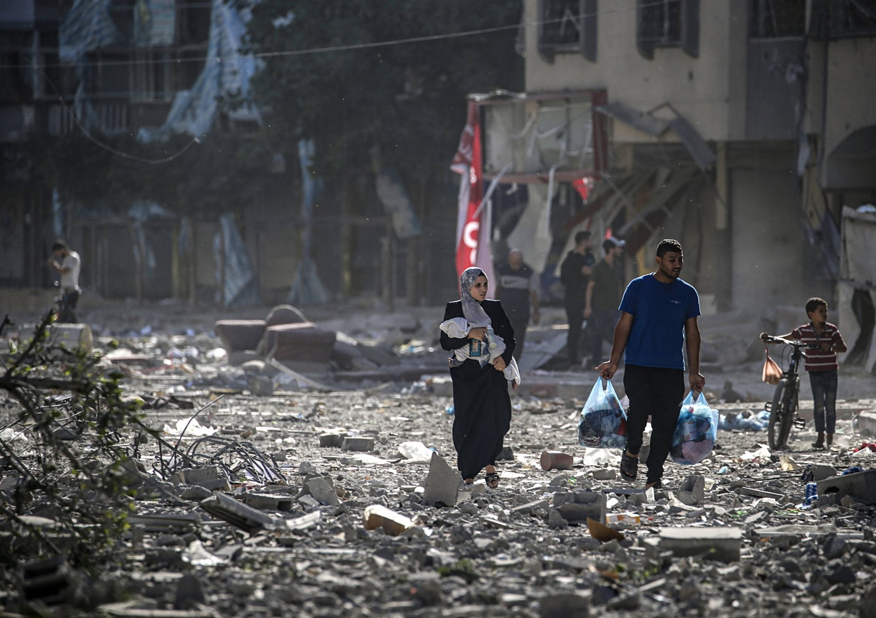 Una familia palestina se abre paso entre los escombros en Ciudad de Gaza.