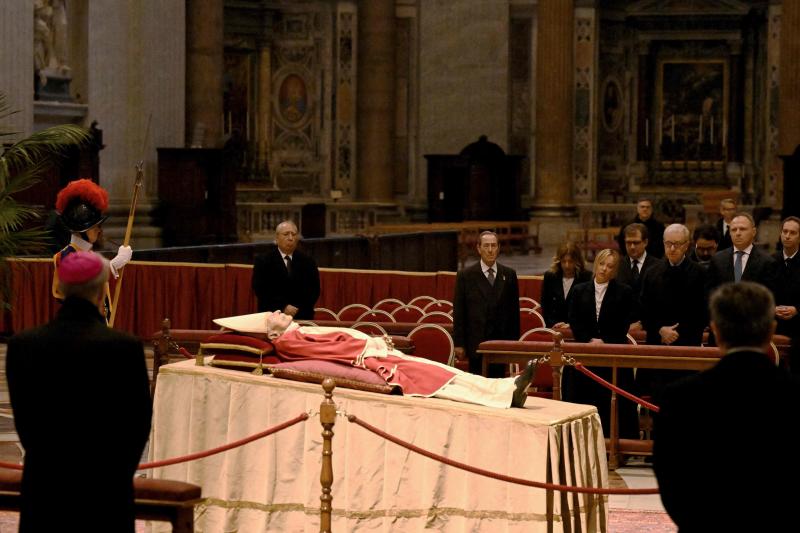 Varias personas rezan ante el cuerpo del papa emérito en la capilla ardiente instalada en la Basílica de San Pedro.